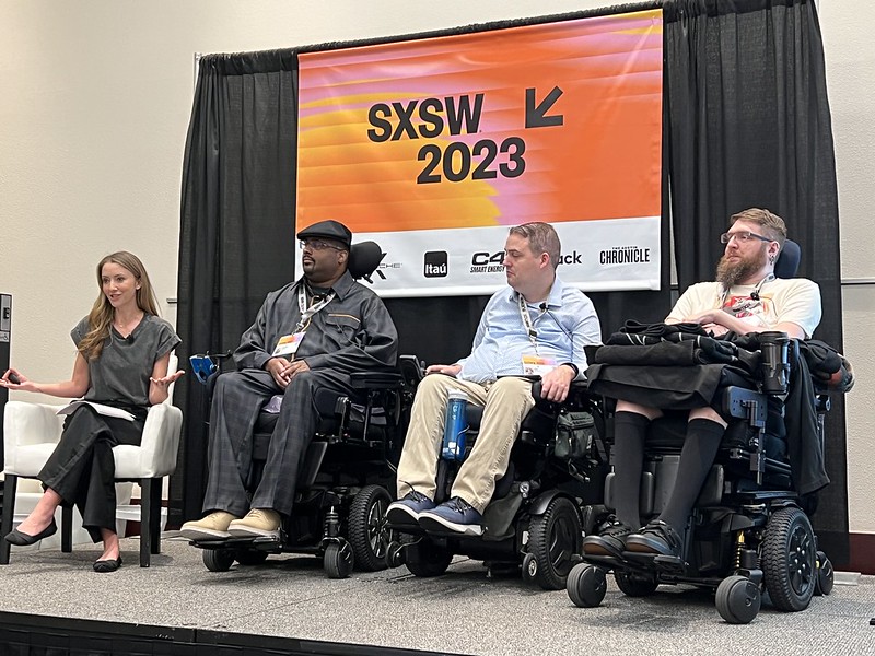 Photo of BCI panel, including three men in wheelchairs